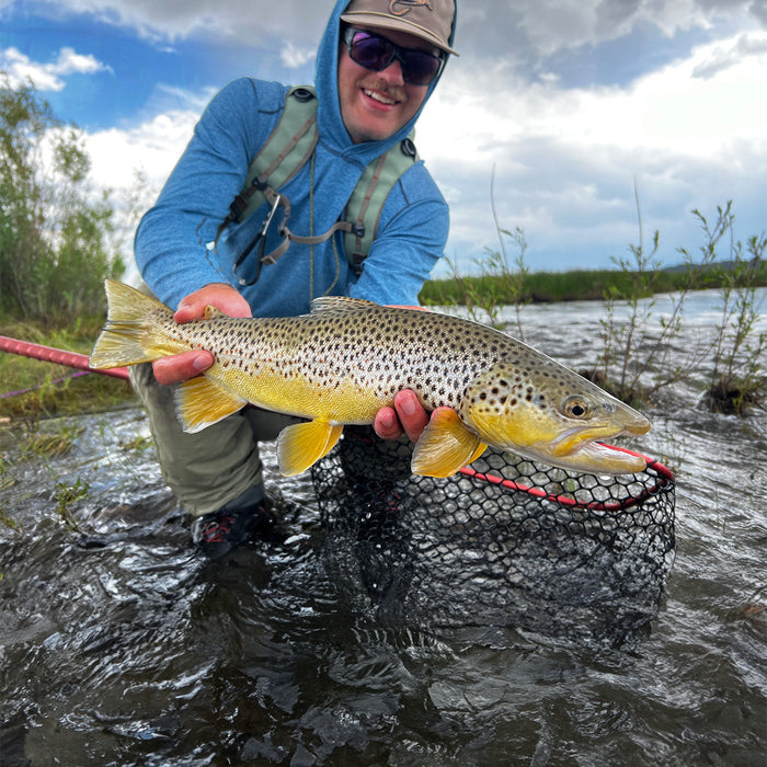 Xavier holding a big brown trout